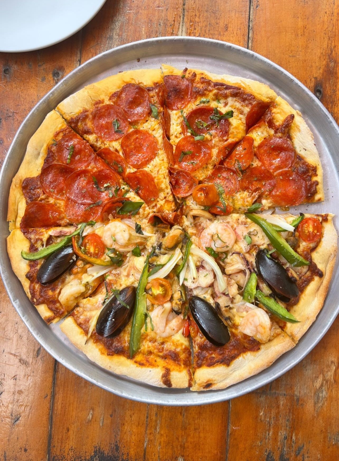 Pizza mitad y mitad recién servida en la mesa